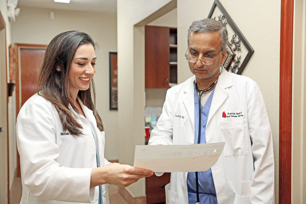 Sunil Gupta, MD, FACC and Michele Gordon, PA-C examining patient document